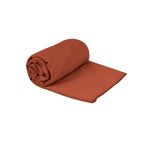 Sea To Summit Drylite Towel in orange color, rolled up with extended portion showing