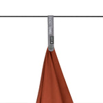 Sea to Summit Pocket Towel in orange color hanging from rail