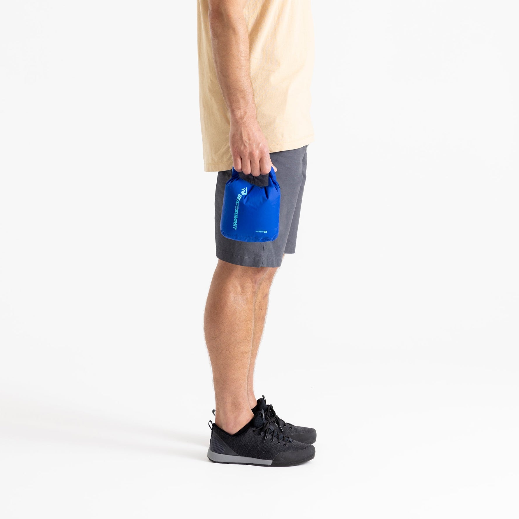 Person holding bright blue Sea To Summit lightweight dry bag