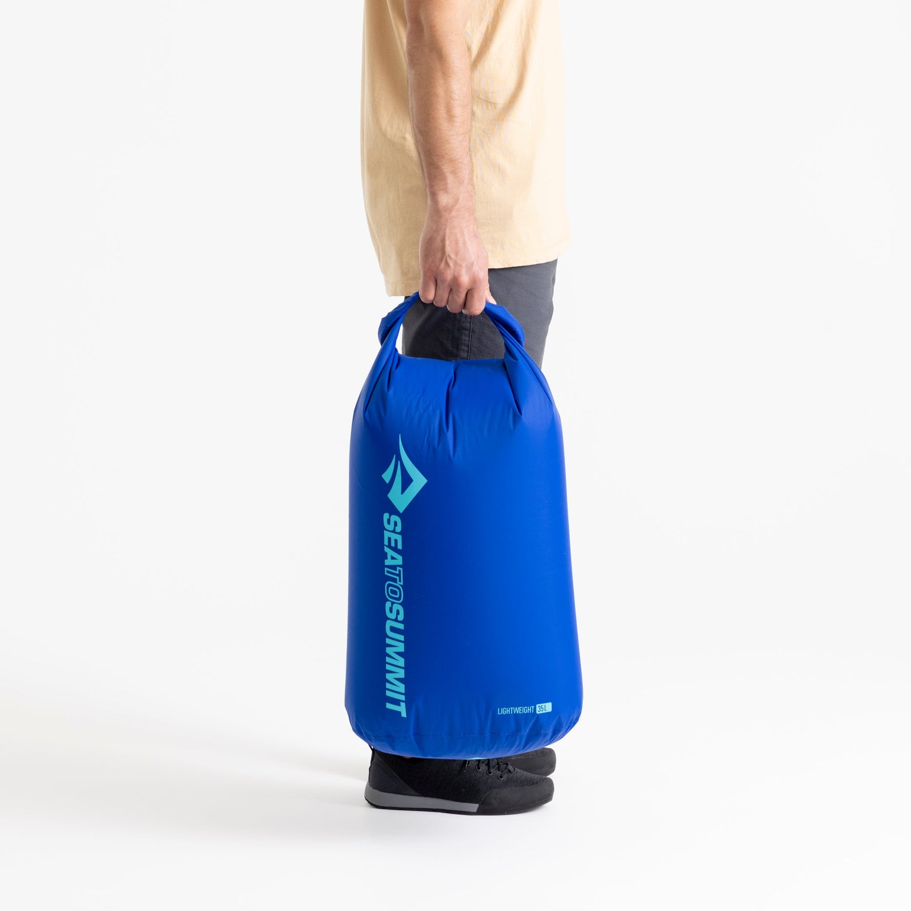 Sea To Summit Lightweight Dry Bag in blue held by person