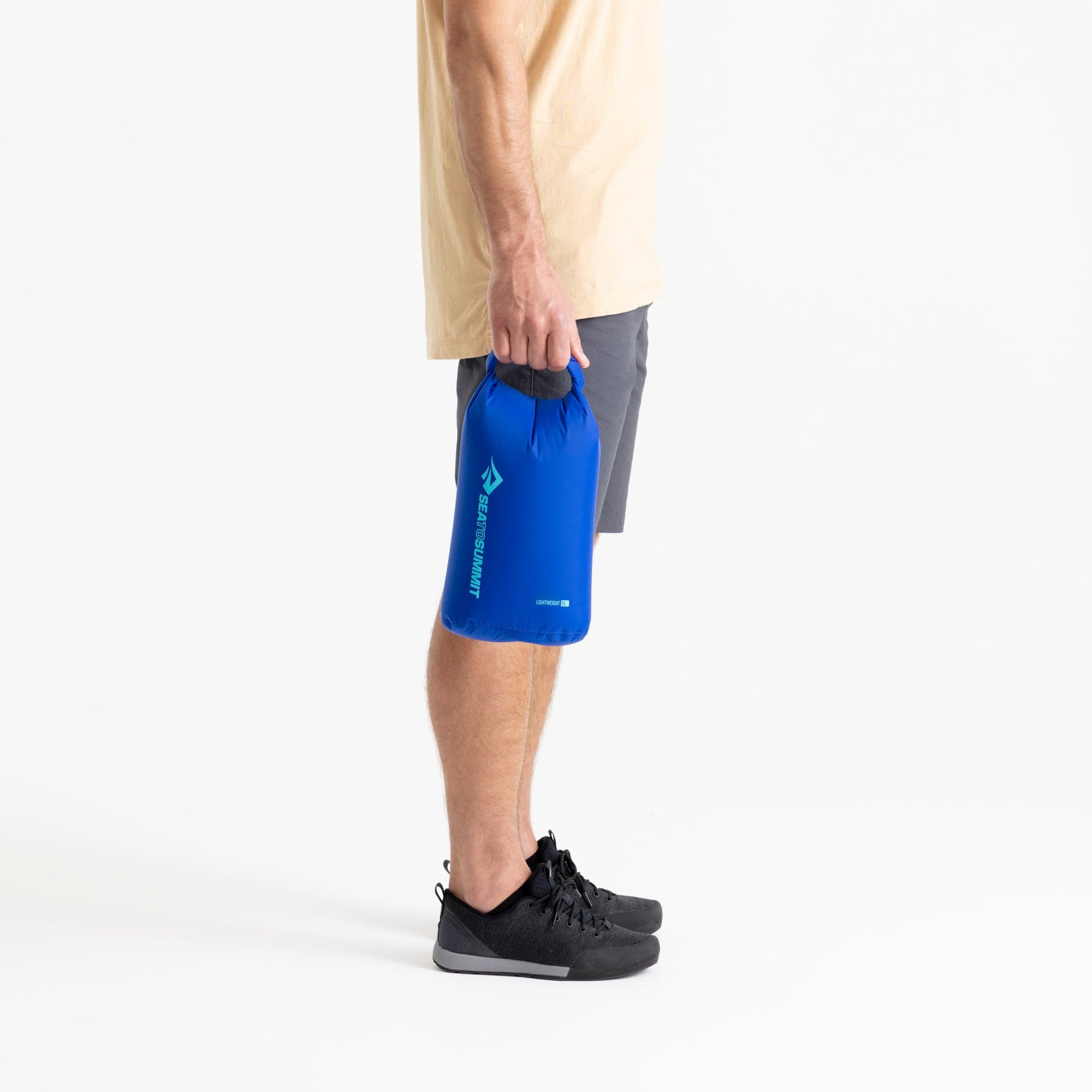 Person holding Sea To Summit Lightweight Dry Bag in surf blue color