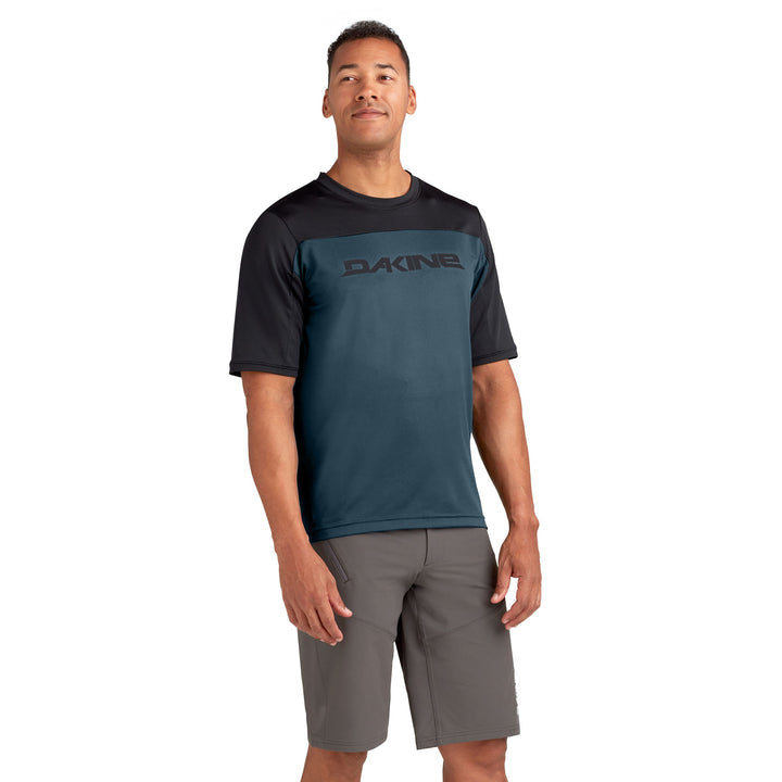 Man wearing Dakine Syncline mountain bike jersey in galactic blue with black shoulders