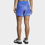 Back view of woman wearing Brooks Chaser 5-inch running shorts in royal blue