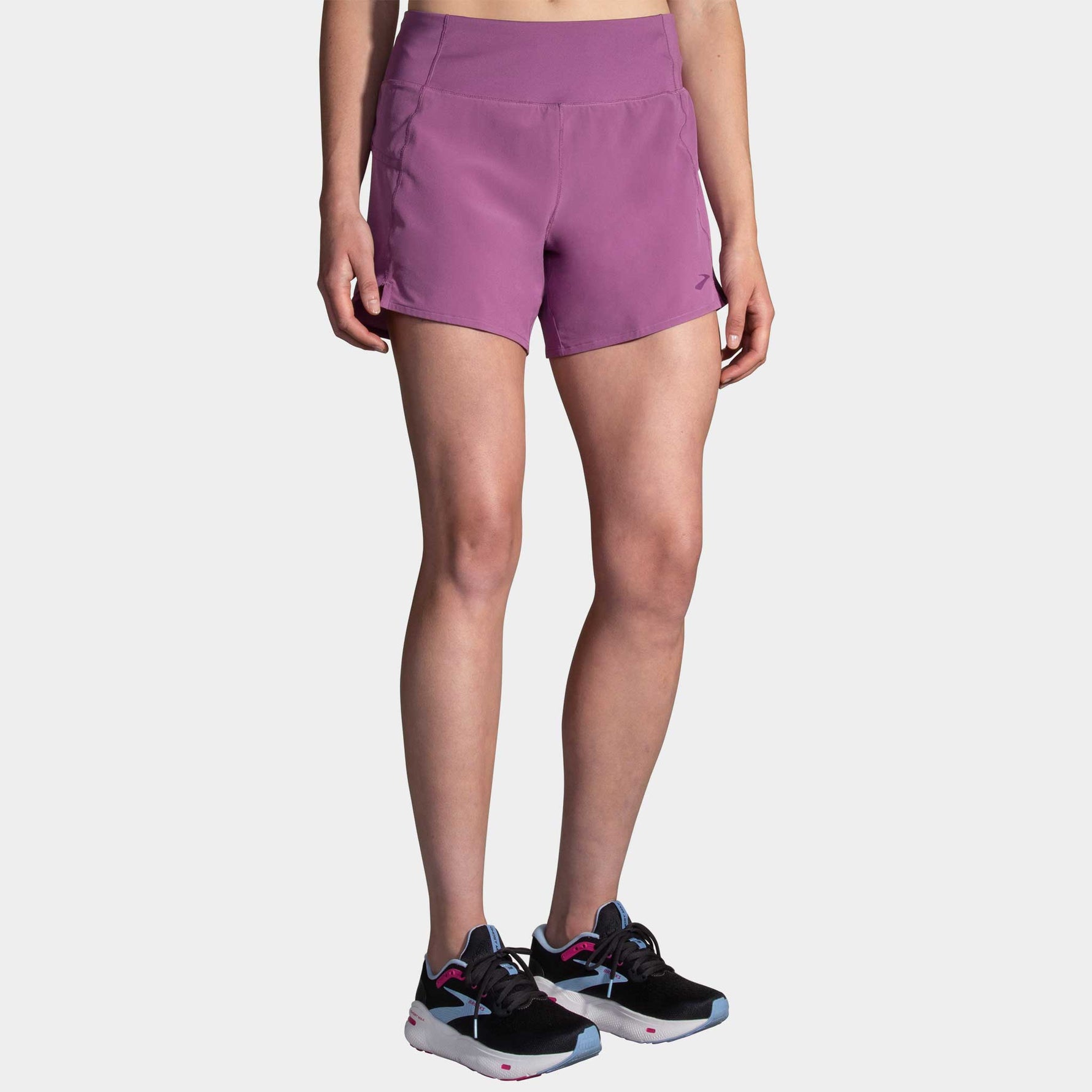 Woman wearing purple Brooks Chaser 5-inch running shorts with athletic shoes