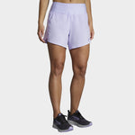 Woman wearing Brooks Chaser 5-inch running shorts in light purple violet color