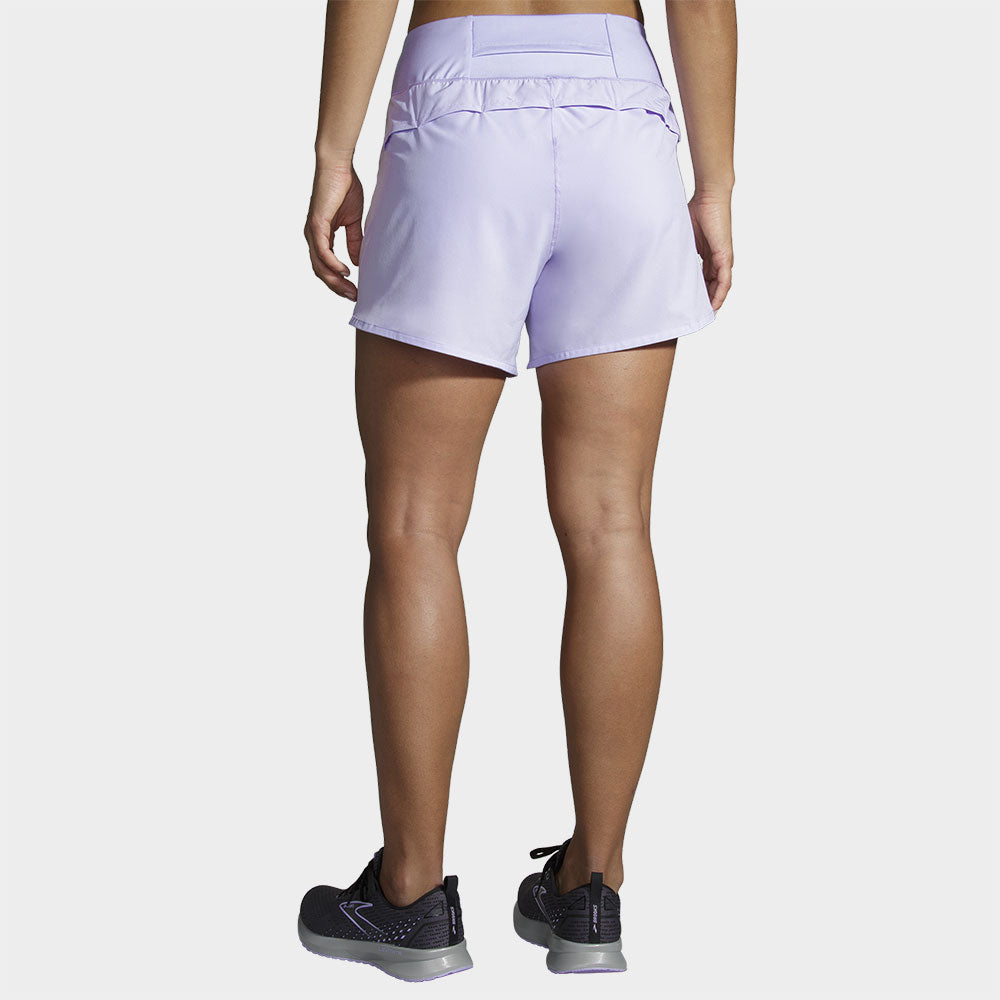 Back view of woman wearing Brooks Chaser 5-inch shorts in light purple