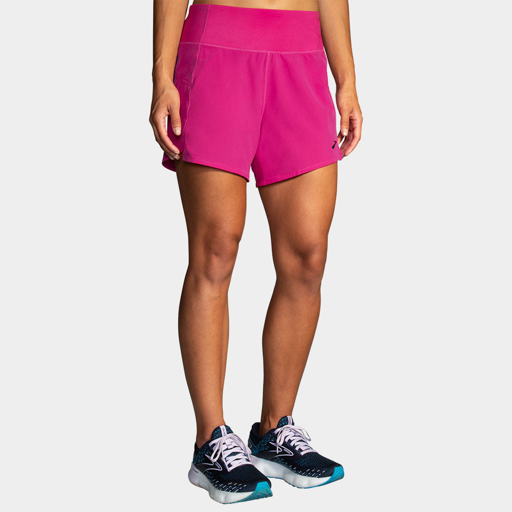 Woman wearing bright pink Brooks Chaser 5-inch running shorts with high waistband