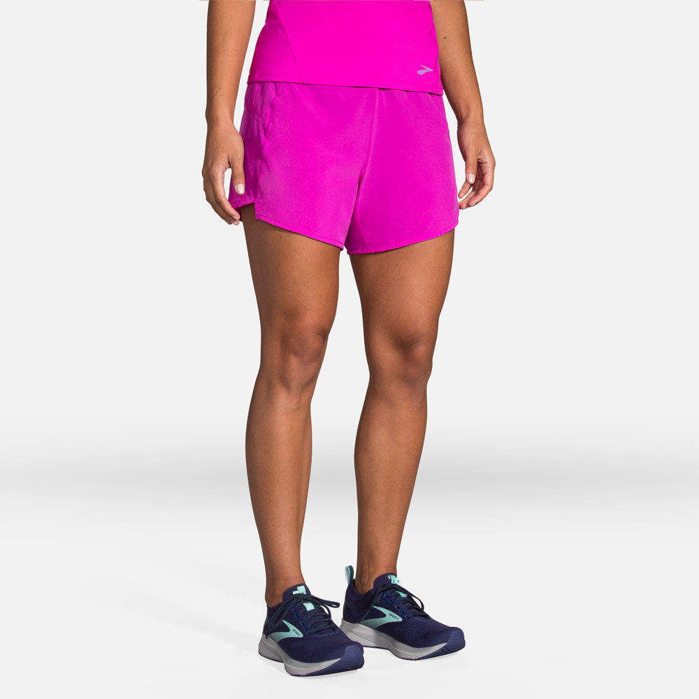 Woman wearing bright pink Brooks Chaser 5-inch running shorts with matching top