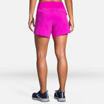 Back view of woman wearing bright pink Brooks Chaser 5-inch running shorts