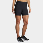 Woman wearing black Brooks Method 5-inch short tights with high waistband and black sneakers