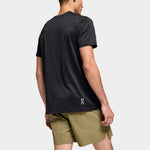 Back view of man wearing black On Core-T shirt with olive green shorts