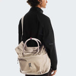 Model wearing sand-colored On Track Pack 35L Lite backpack with shoulder strap