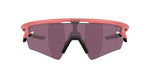 Oakley Sphaera sunglasses with coral pink frame and dark purple lenses on white background