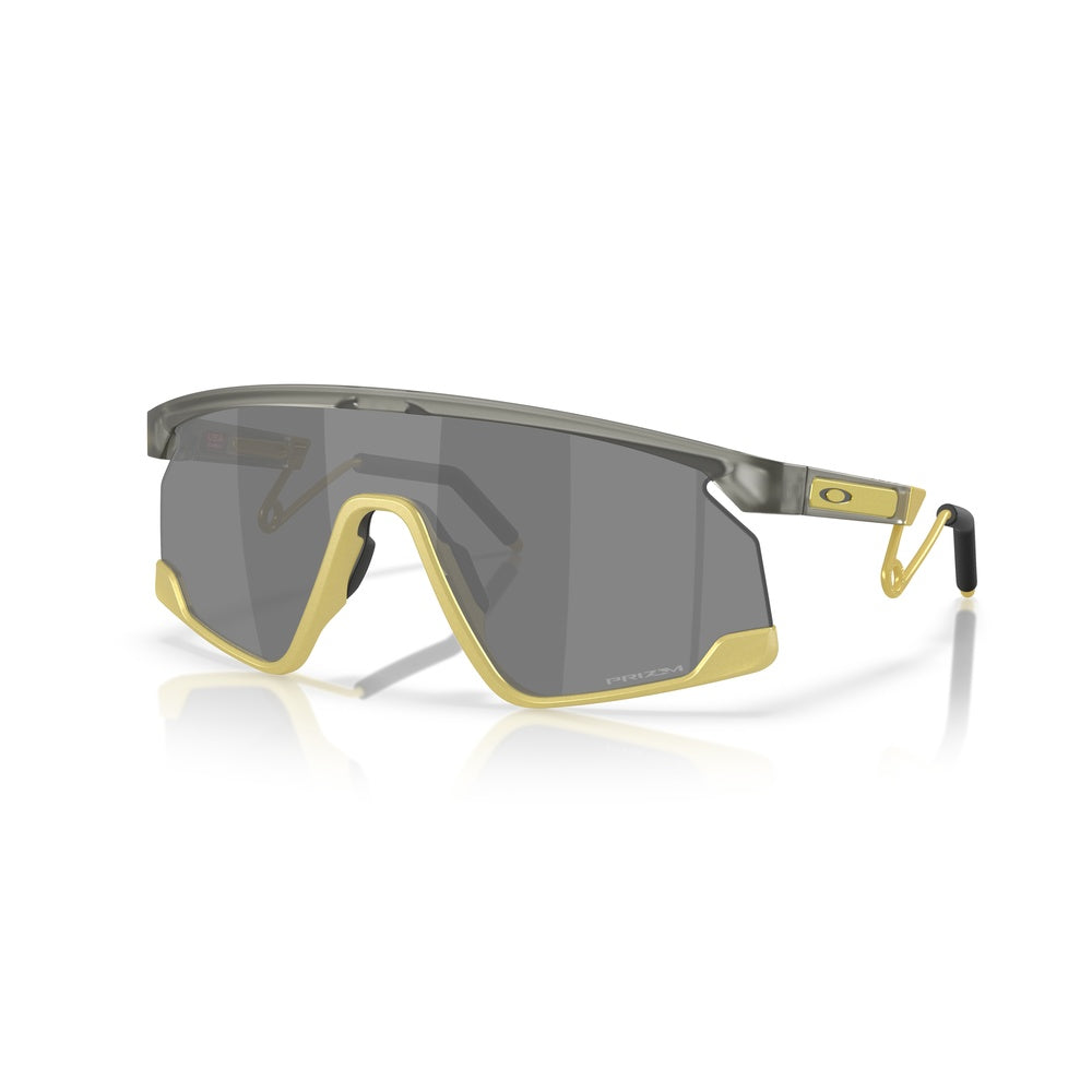 Oakley BXTR sunglasses with matte grey frame, gold accents, and dark lenses