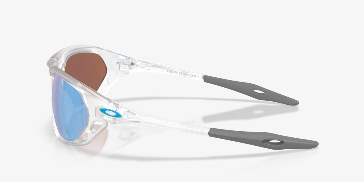 Oakley Cage Jacket sunglasses top-down view showing clear frame, blue lenses, and grey temple tips