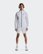 Male model wearing On white hooded jacket and white performance shorts with sneakers