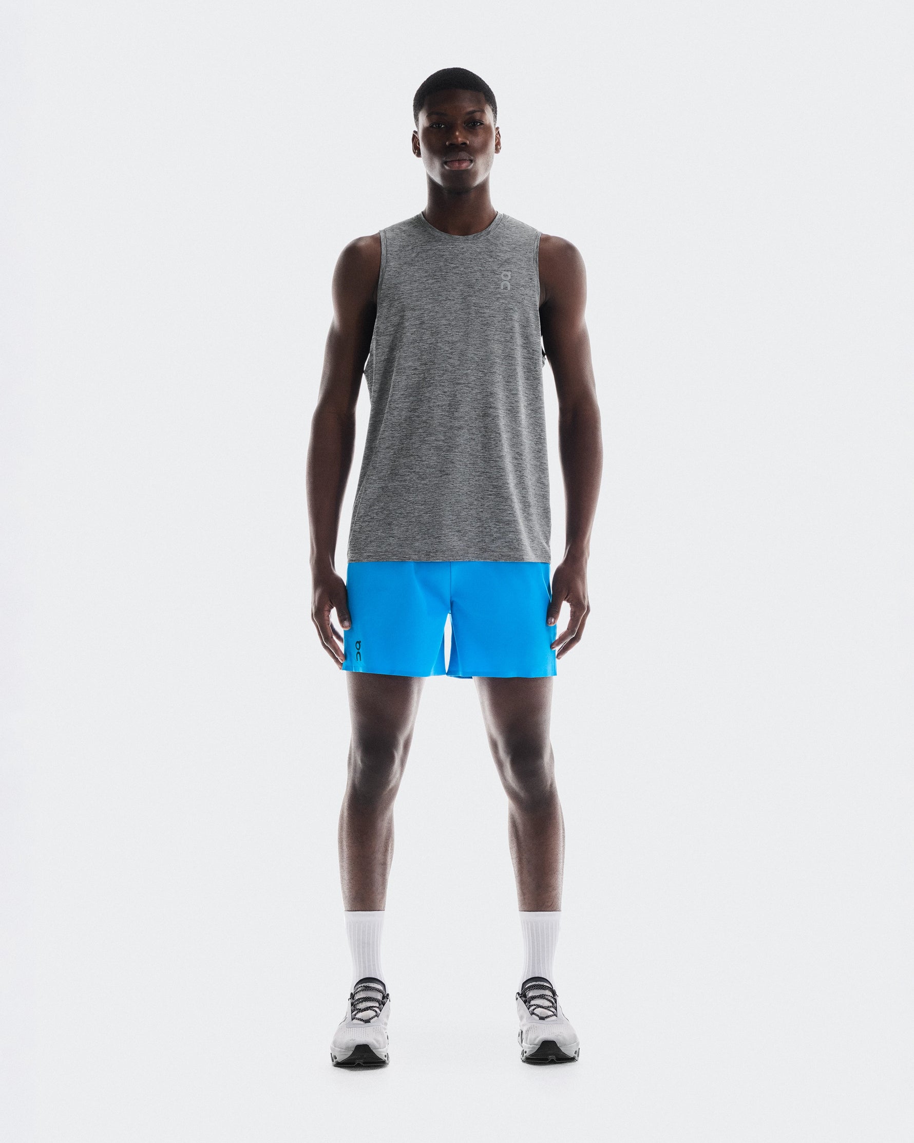 Athletic man wearing On 5-inch Performance Shorts in bright blue with gray tank top