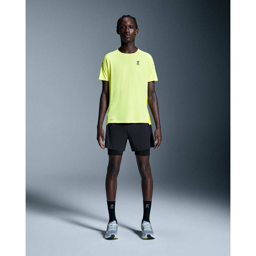 Man wearing On 5 inch Performance 2/1 Shorts in black with yellow shirt
