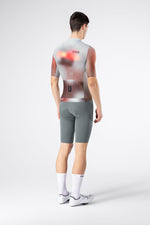 Male cyclist wearing Gobik Attitude 2.0 jersey rear view with gray bib shorts on white background