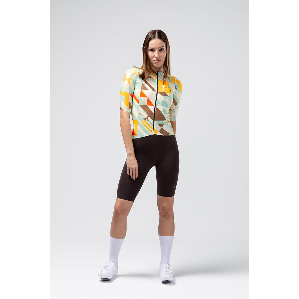 Woman wearing Gobik Attitude 2.0 cycling jersey with colorful geometric pattern and black shorts