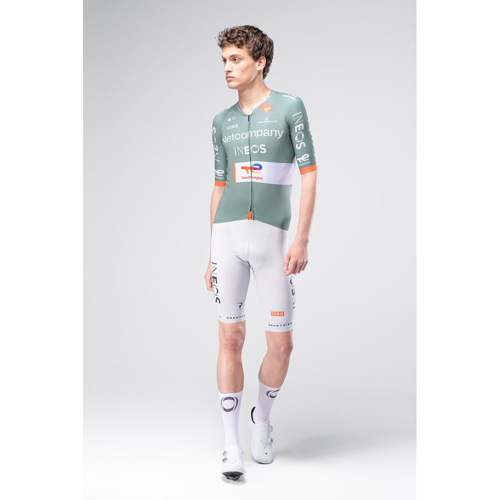 Male model wearing Gobik INEOS Grenadiers Netcompany cycling jersey and white bib shorts