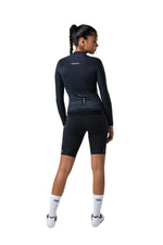Woman wearing black Gobik Avalon long sleeve cycling jersey and shorts from behind