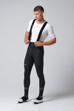 Man wearing black Gobik Absolute 7.0 bib shorts with white shirt and cycling shoes