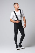 Male cyclist wearing black Gobik Absolute 7.0 bib shorts with suspenders and white jersey