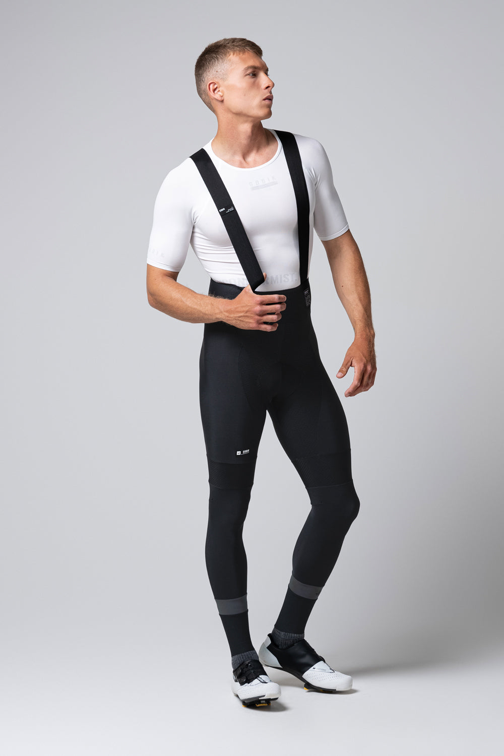Male cyclist wearing black Gobik Absolute 7.0 bib shorts with suspenders and white jersey
