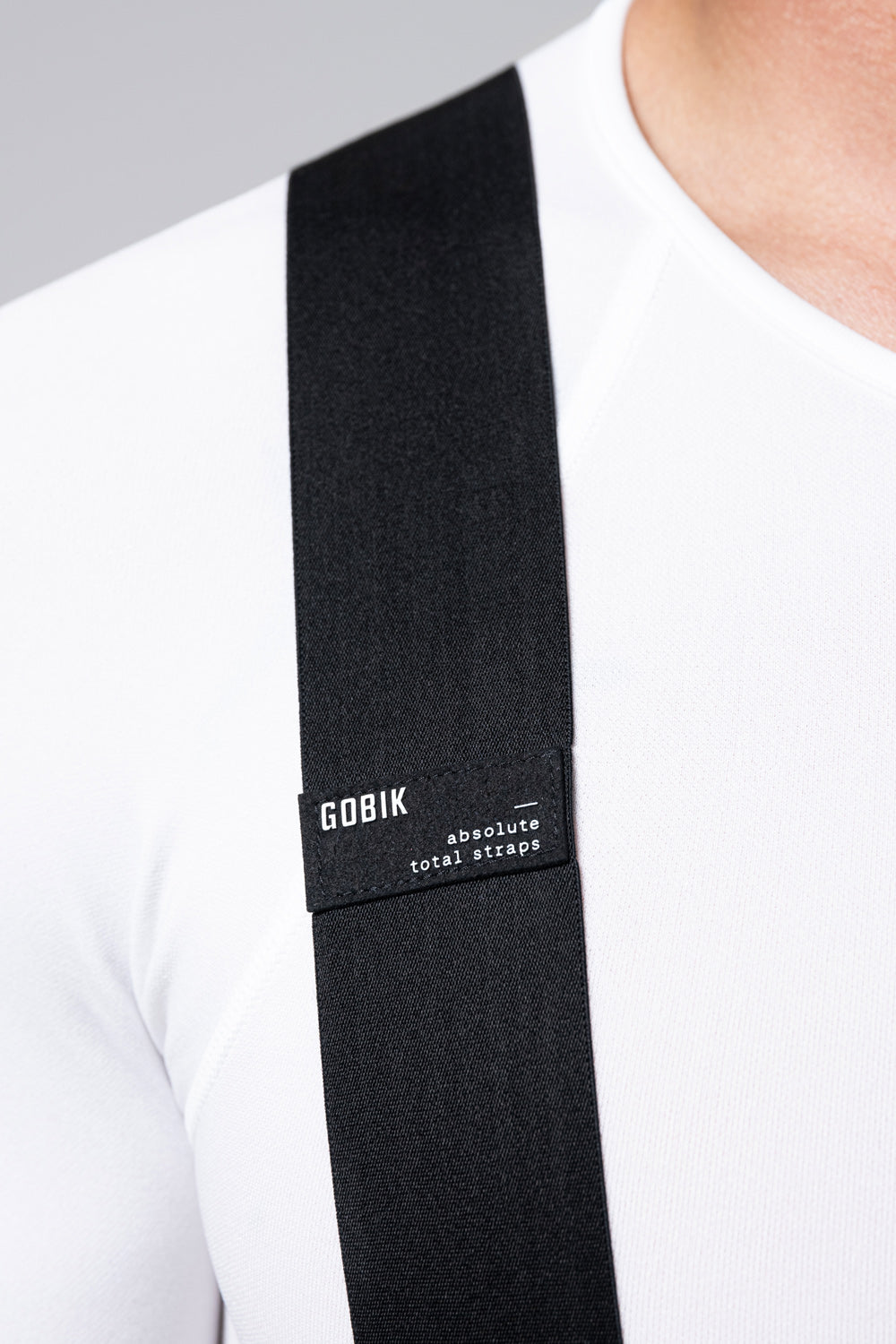 Close-up of black Gobik cycling bib short strap on model's shoulder