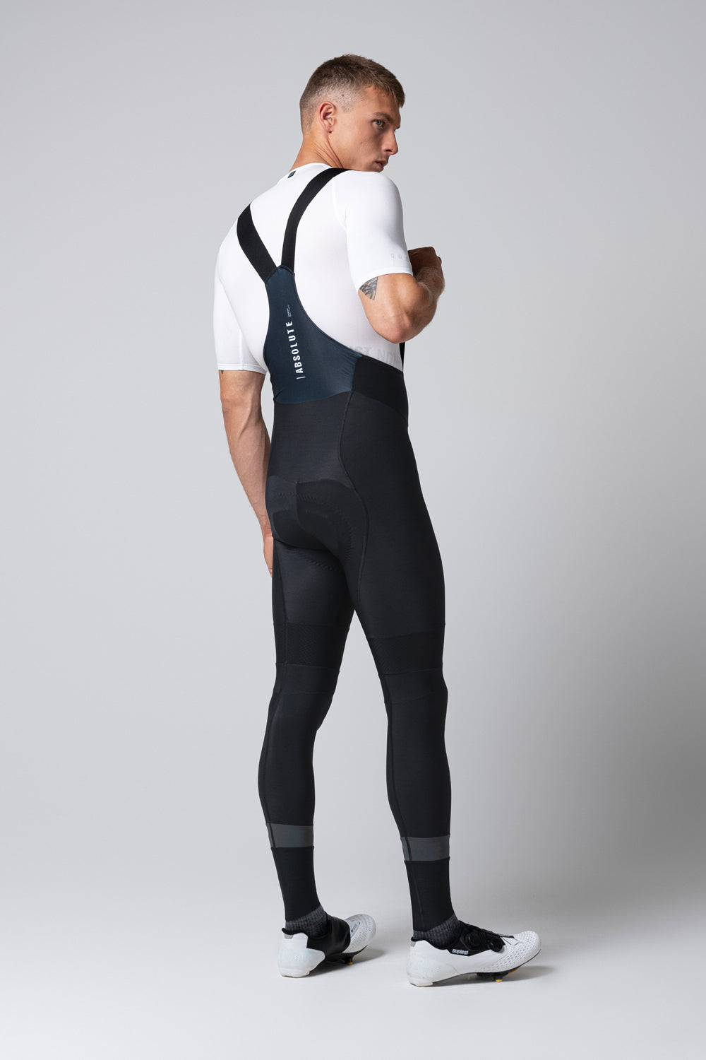 Man wearing black Gobik Absolute 7.0 bib shorts with suspenders, rear view
