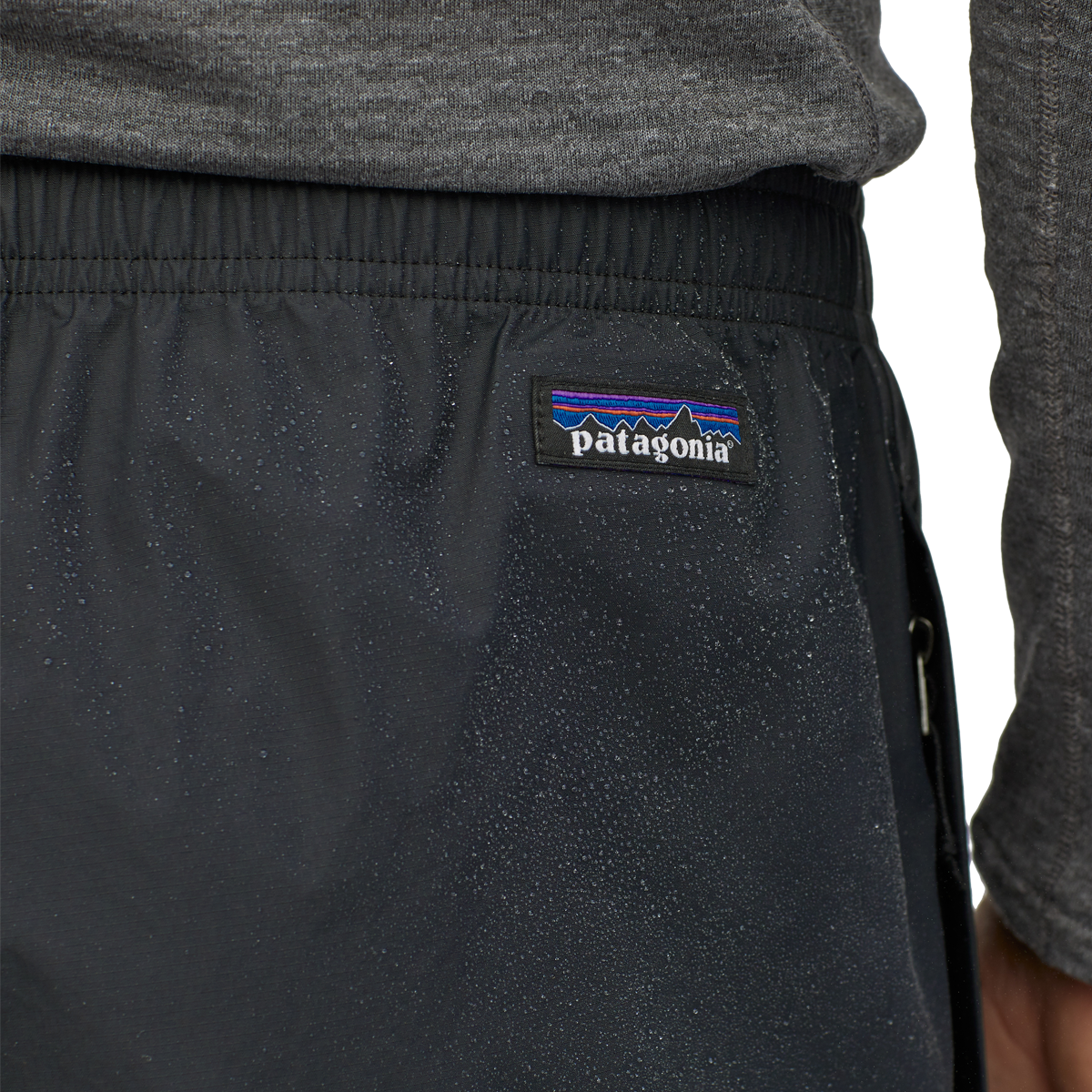 Close-up of black Patagonia Torrentshell pants showing waistband and logo patch