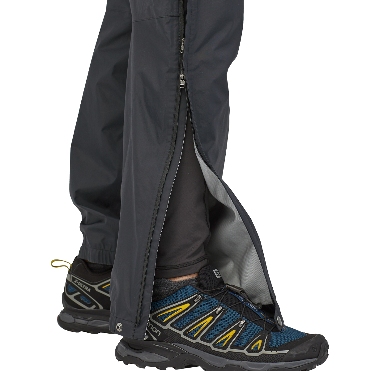 Black Patagonia Torrentshell 3L pants with side zip vents and trail running shoes