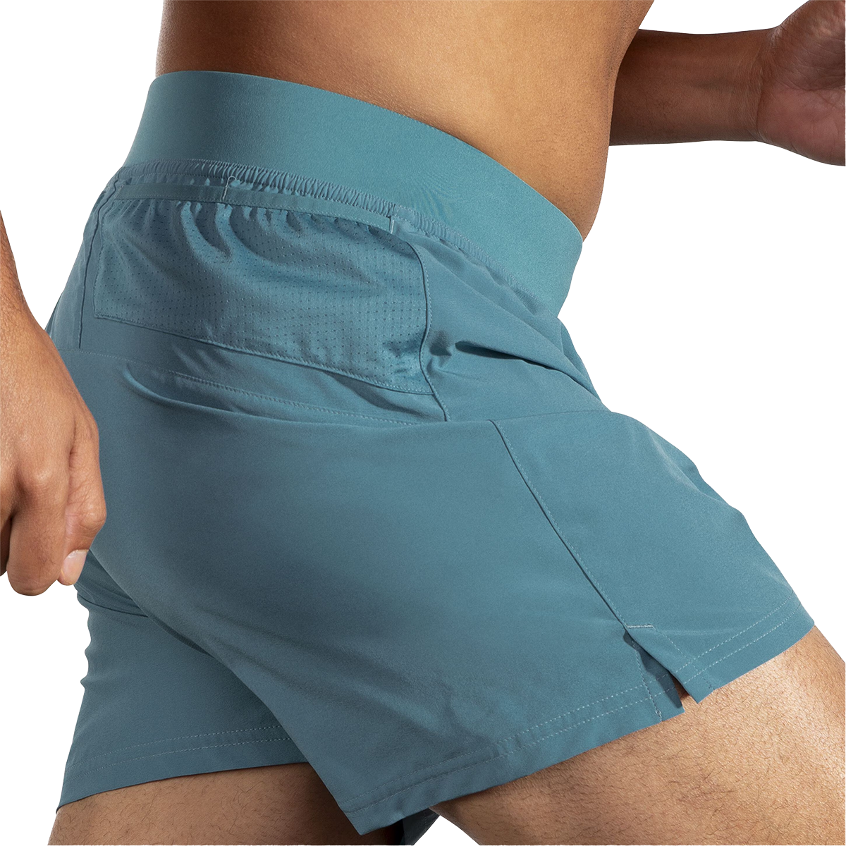 Close-up side view of Brooks Sherpa 5-inch men's shorts in Storm Blue showing perforated mesh side pocket detail on male model