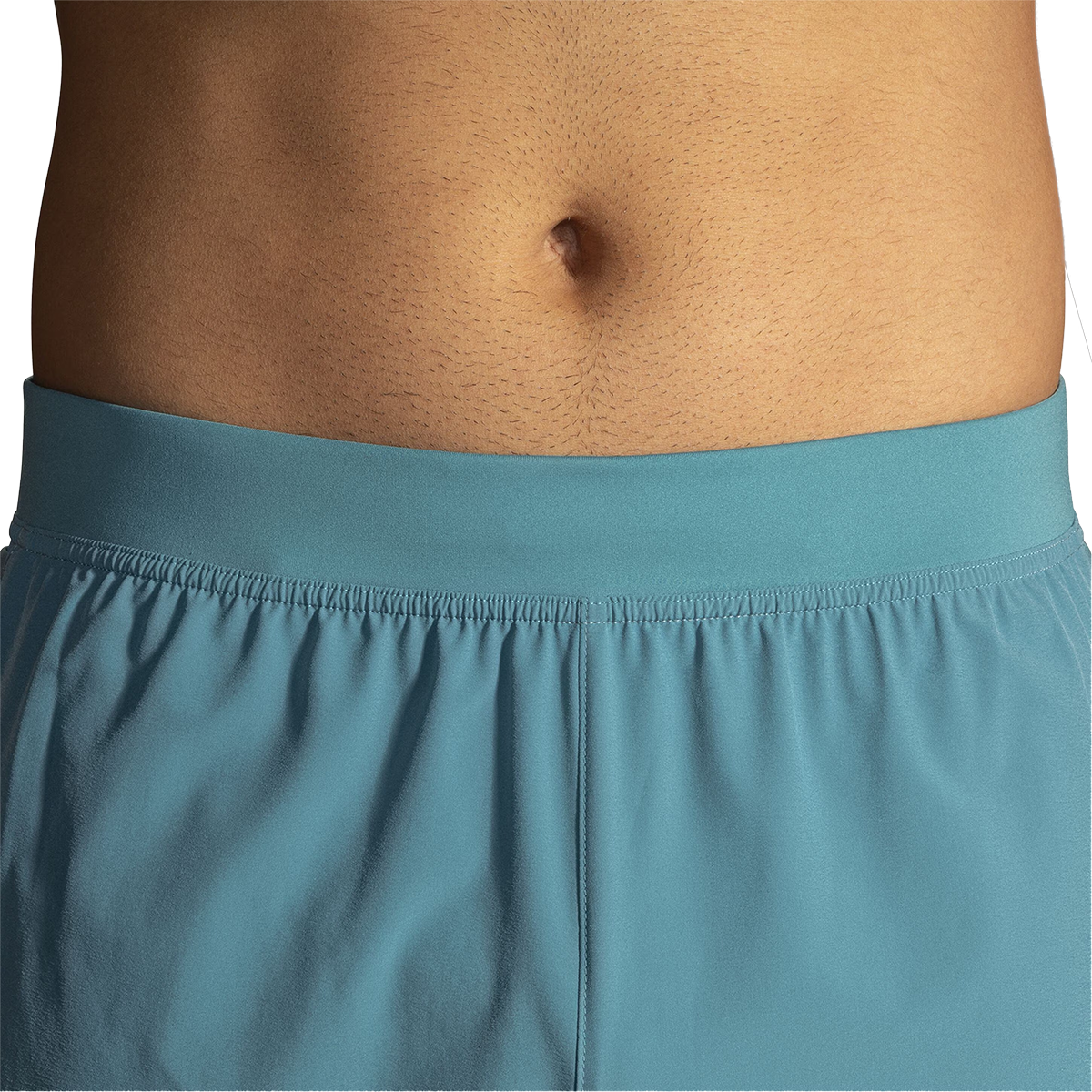 Close-up detail of Brooks Sherpa 5-inch shorts waistband in Storm Blue showing elastic gathered construction on male torso