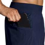 Man wearing Brooks Sherpa navy shorts with phone in zippered side pocket