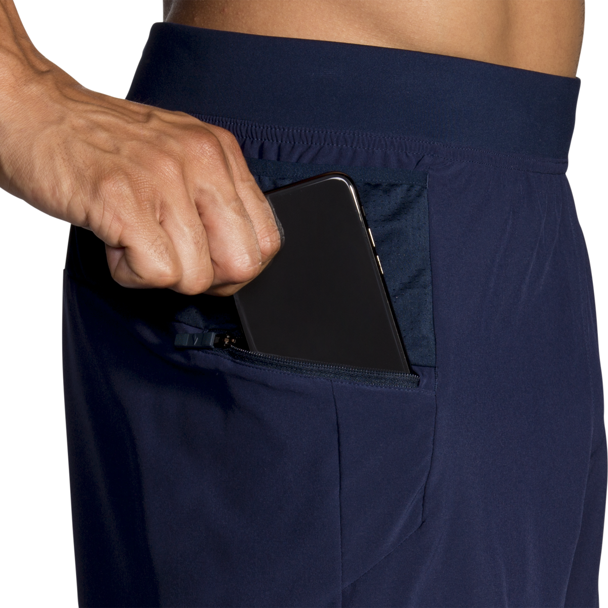 Man wearing Brooks Sherpa navy shorts with phone in zippered side pocket