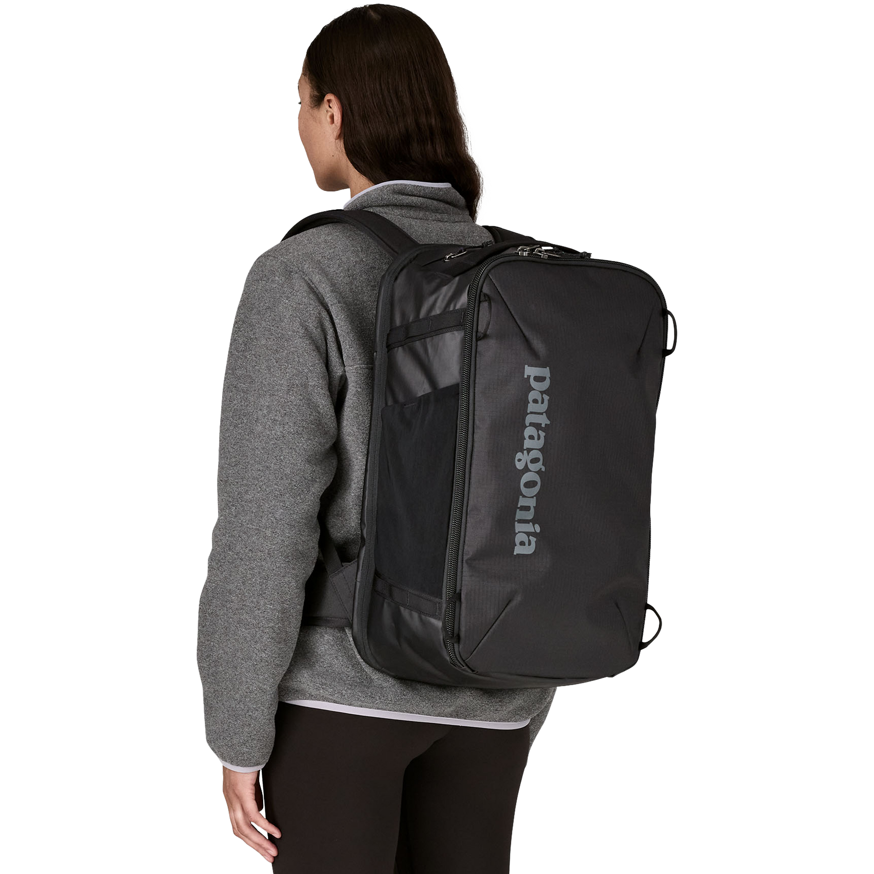 Woman wearing black Patagonia Black Hole Mini MLC backpack from behind