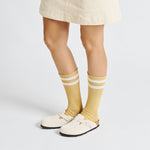 Birkenstock Boston clogs in light beige suede worn with yellow striped socks