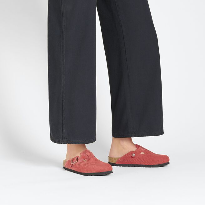 Birkenstock Boston clogs in coral red suede with embossed texture on model's feet