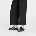 Black Birkenstock Boston Exquisite clogs worn with dark cropped pants on white background