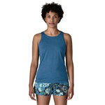 Woman wearing blue Patagonia tank top with tropical patterned shorts