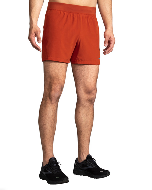 Brooks Sherpa 5 inch running shorts in red clay color on male model