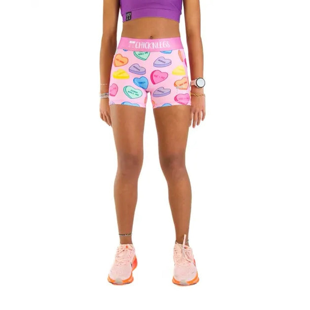 Woman wearing pink compression shorts with colorful candy hearts pattern