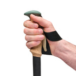 Hand gripping Black Diamond Trail Cork trekking pole with green grip and wrist strap