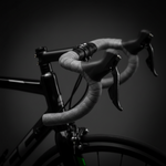 Grey patterned bar tape wrapped on road bike handlebars in studio lighting