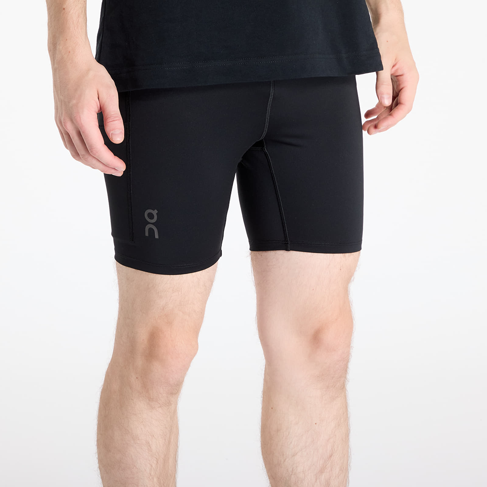 Man wearing black On Performance Hybrid running shorts with logo on thigh