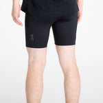 Man wearing black On Performance Hybrid Shorts with On logo on thigh