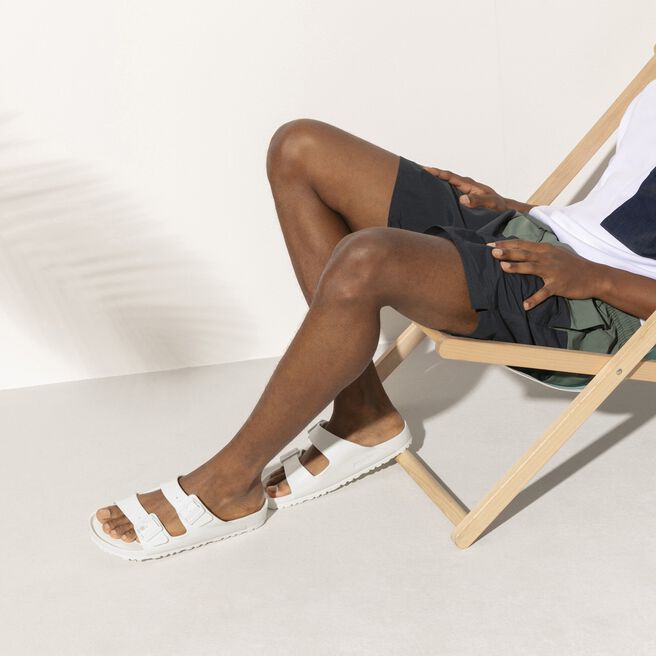 White Birkenstock Arizona EVA sandals worn by model in studio setting