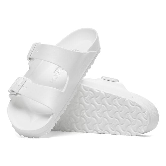 White Birkenstock Arizona Essentials EVA sandals with two adjustable straps on white background